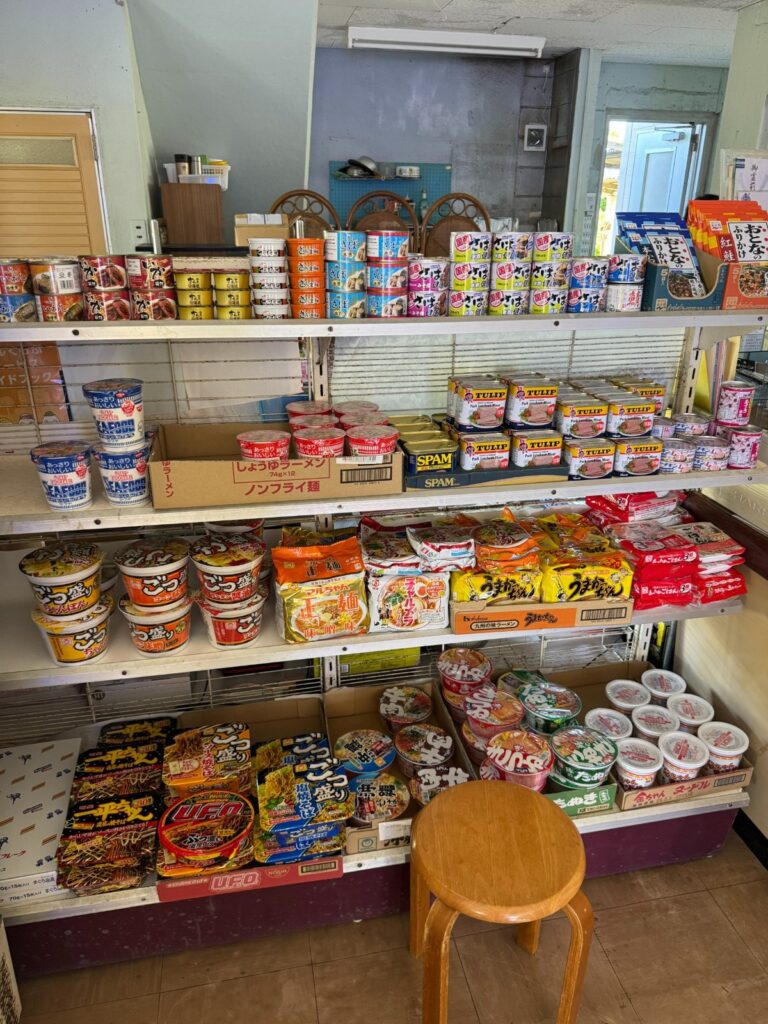 森乃商店の棚にずらりと並ぶカップ麺と缶詰。TULIP缶詰やうまかっちゃん、SPAMも完備。