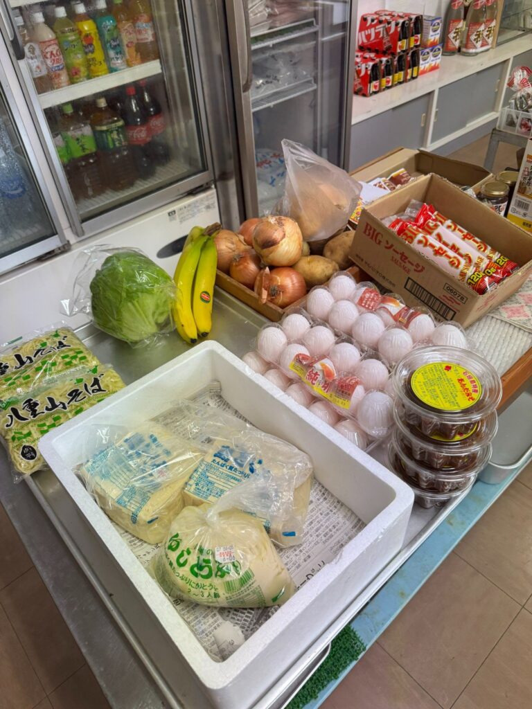 森乃商店の生鮮食材コーナー。卵、野菜、八重山そば、島豆腐などが並んでいる/Fresh food section at Morino Store with eggs, vegetables, Yaeyama soba, and island tofu