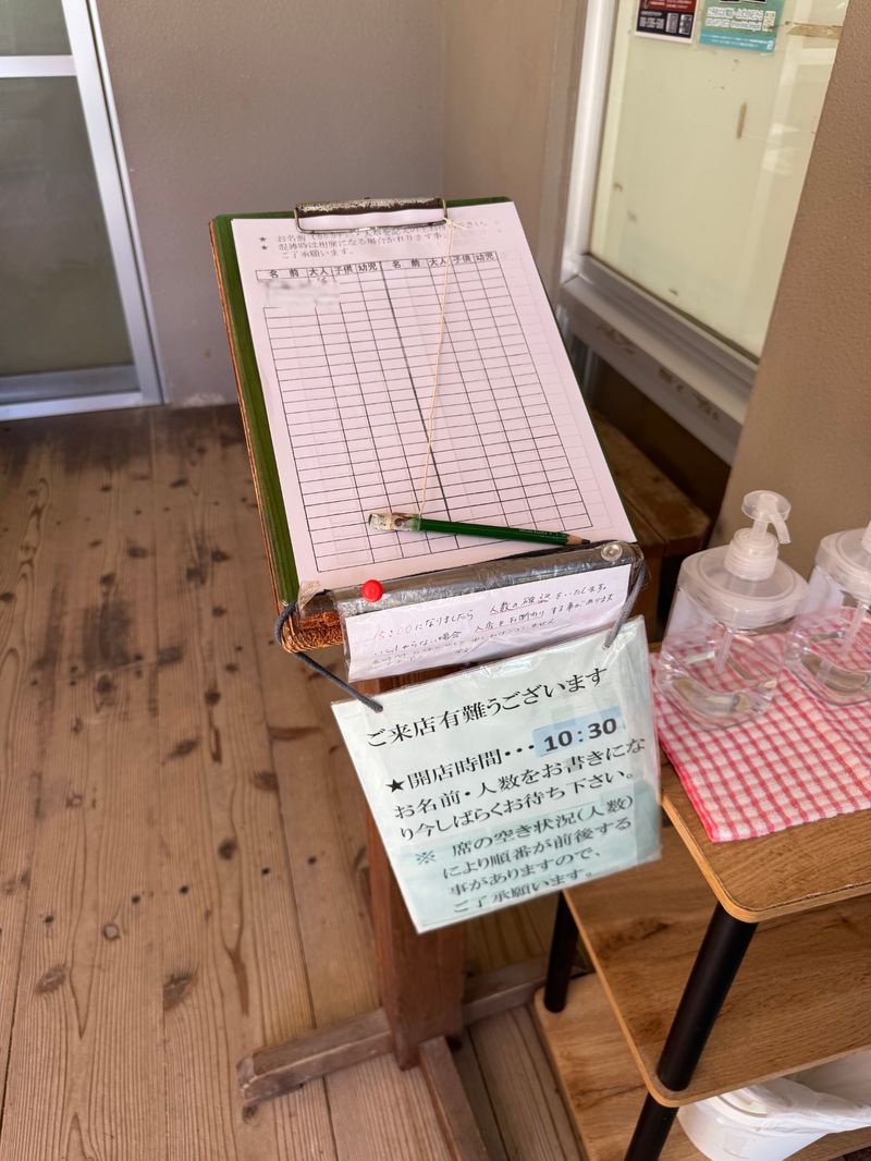石垣島・明石食堂の玄関に設置された予約記帳簿。入口で名前と人数を書いておくことで、順番が確保されるローカルルール。事前に知っていないと損をする、島時間を有効活用できる仕組み。
